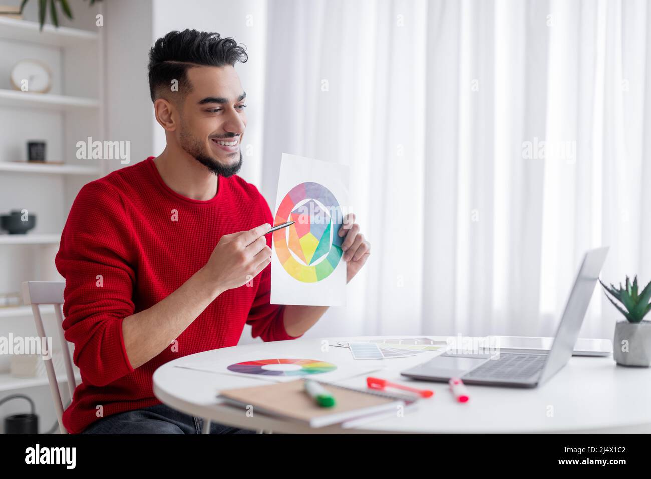 Froh attraktive Millennial islamischen männlichen Blogger mit Bart zeigt Farbkarte zu Laptop Web-Kamera Stockfoto