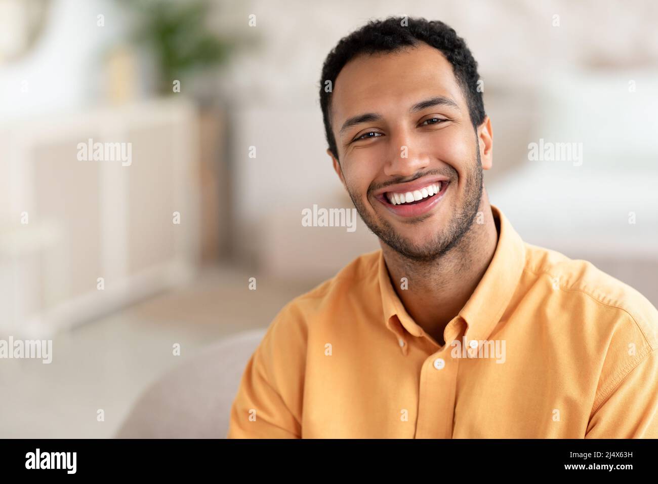 Porträt eines lächelnden jungen Mannes, der vor der Kamera posiert Stockfoto
