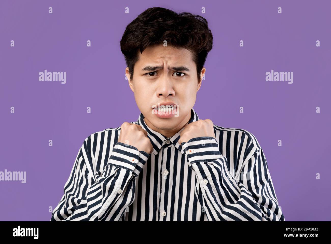 Porträt eines verängstigten asiatischen Mannes, der die Fäuste zum Kämpfen zusammenhält Stockfoto