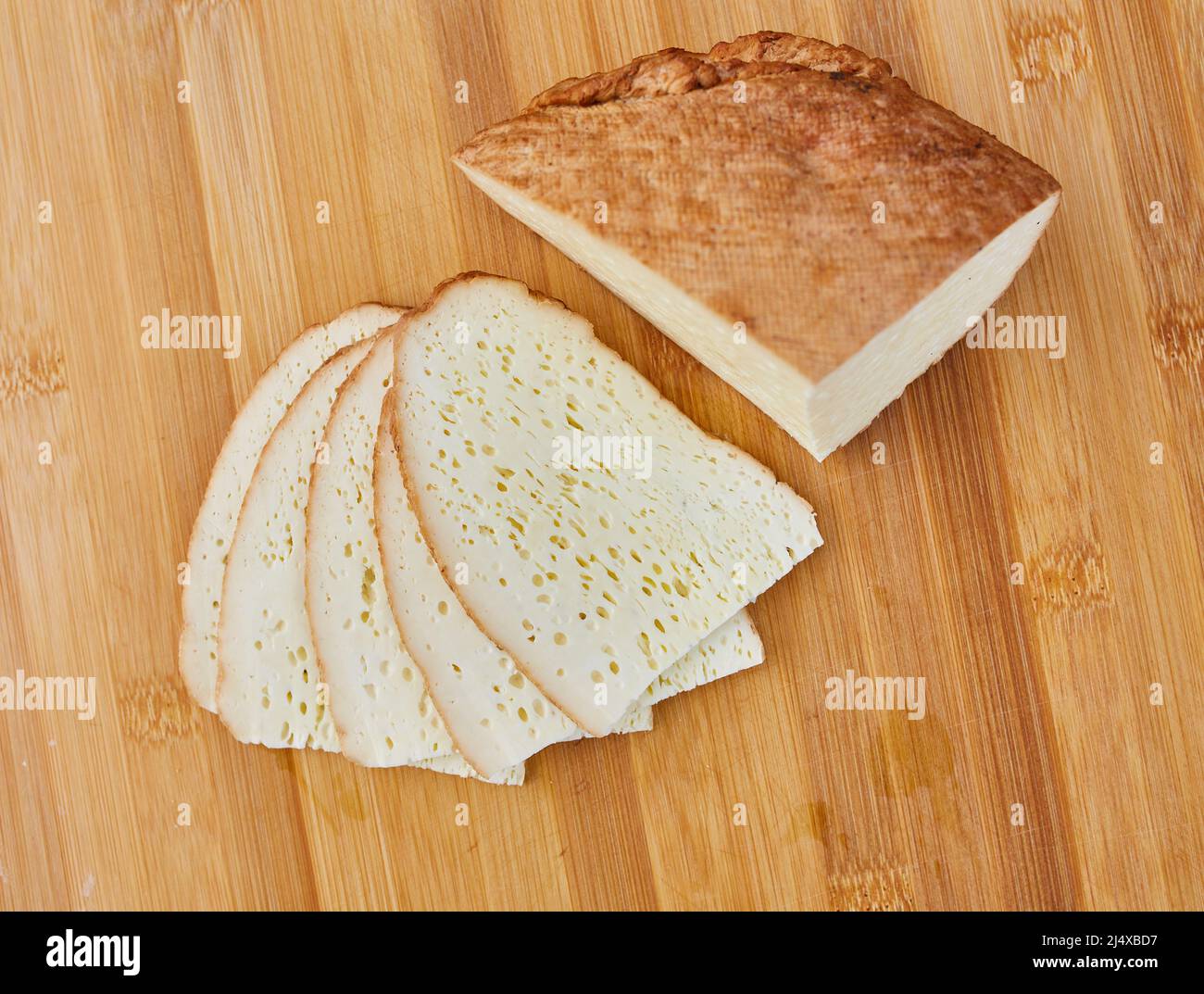 Hausgemachter geräucherter Käse auf einem Holzbrett geschnitten Stockfoto