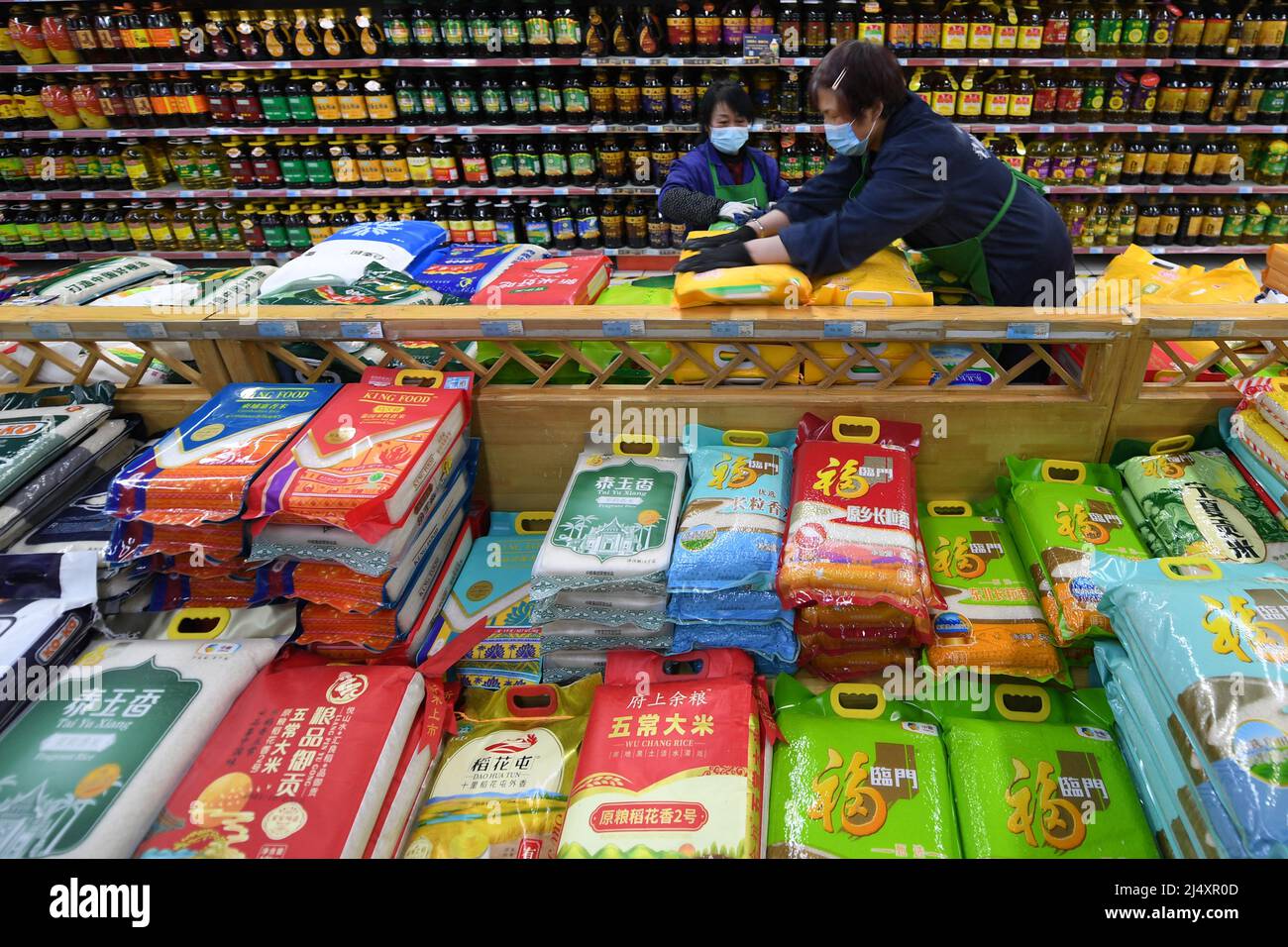 Xining, Chinas Provinz Qinghai. 18. April 2022. Mitarbeiter arbeiten in einem Supermarkt in der Stadt Xining, nordwestlich der chinesischen Provinz Qinghai, 18. April 2022. Die lokalen Behörden haben Maßnahmen ergriffen, um die Versorgung sicherzustellen, und in der Zwischenzeit haben sie Teams eingerichtet, um lebende Güter für die Bewohner der kontrollierten Gemeinden zu kaufen und zu verteilen, während das jüngste Wiederaufleben von COVID-19-Infektionen aufkommt. Quelle: Fan Peissen/Xinhua/Alamy Live News Stockfoto