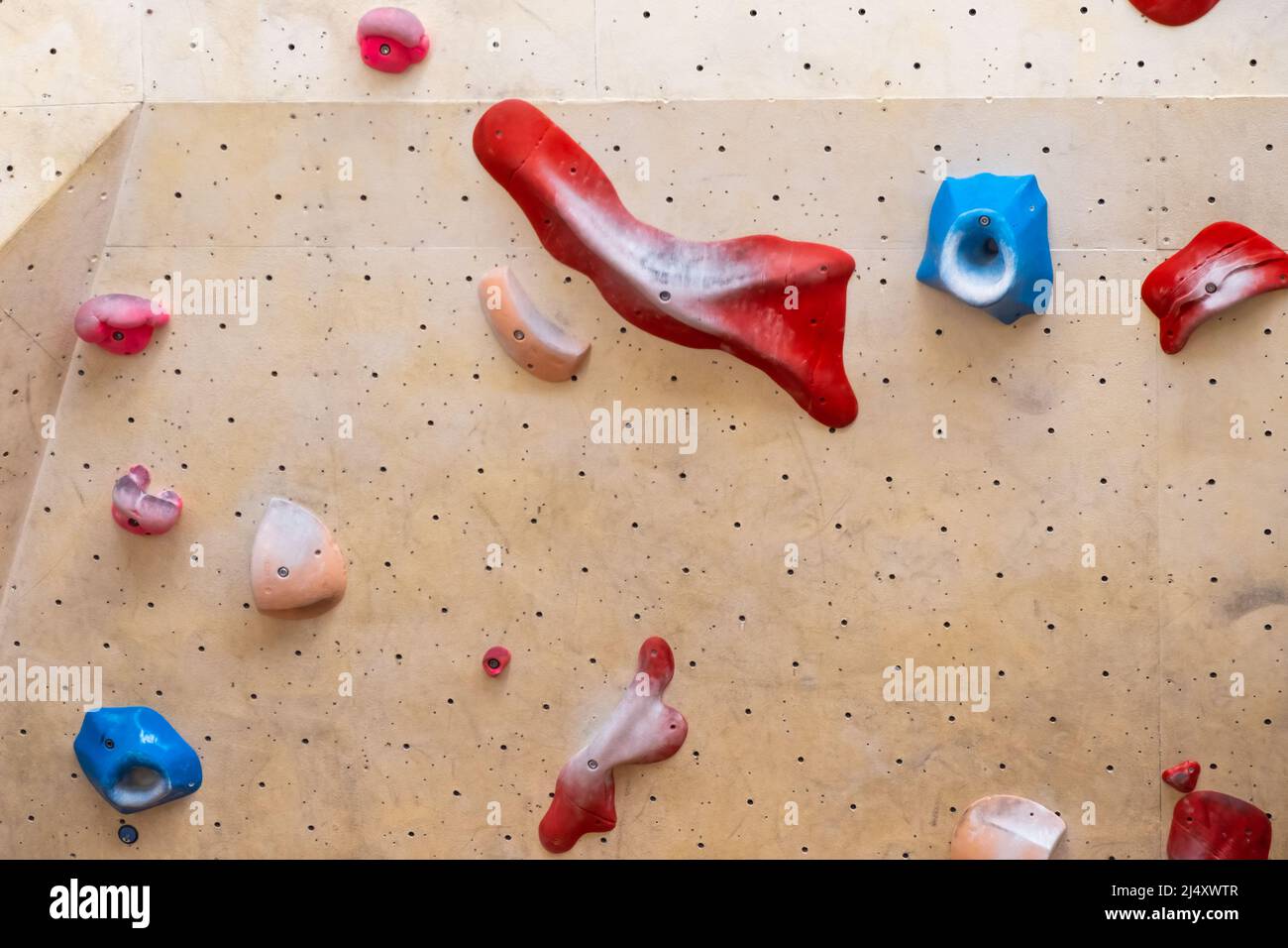 Steinhaken oder Griffe an der künstlichen Kletterwand in der Boulderhalle. Stockfoto
