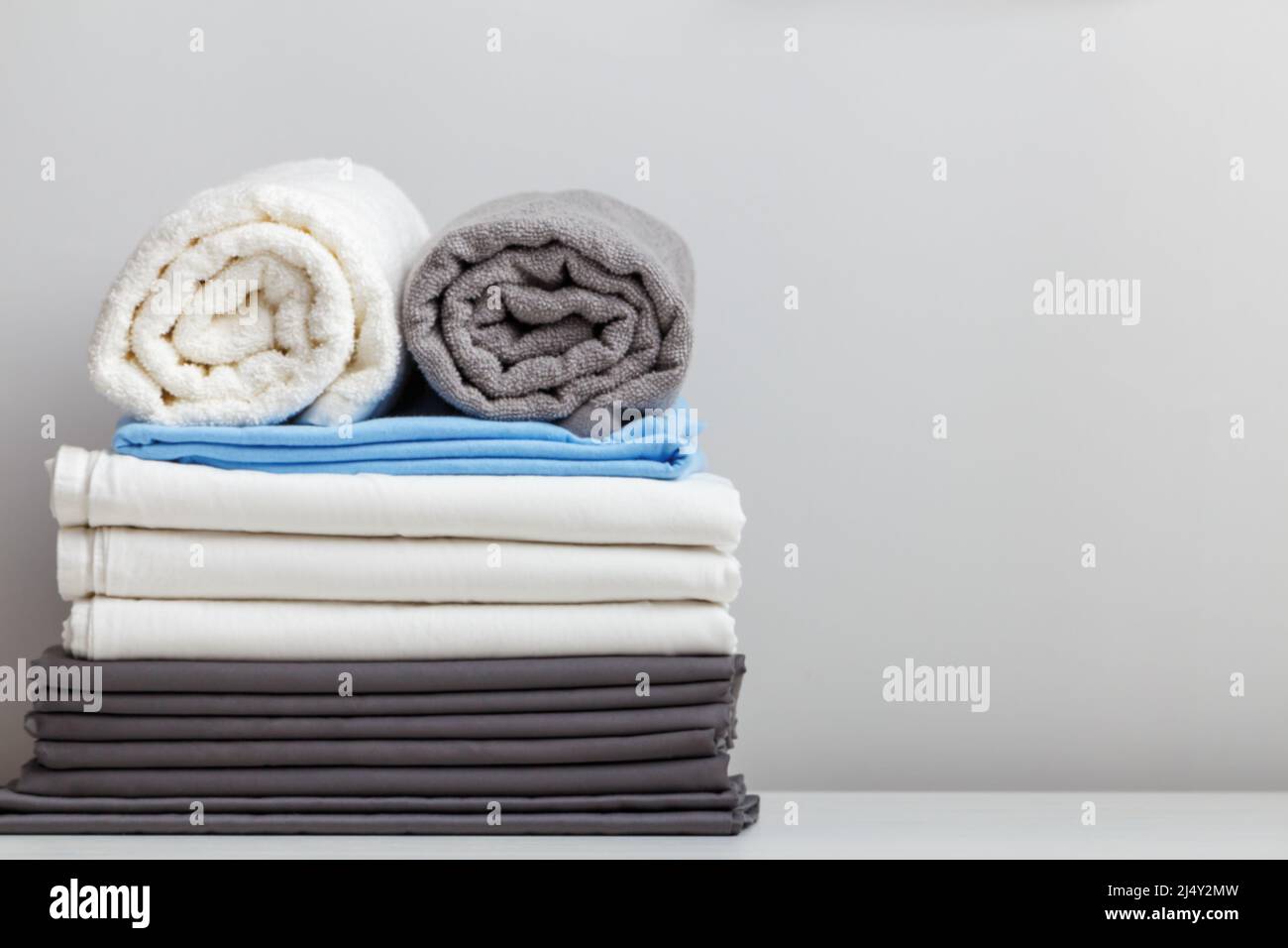 Ein Stapel Bettwäsche, Bettwäsche und Handtücher auf dem Tisch. Platz zum Kopieren Stockfoto