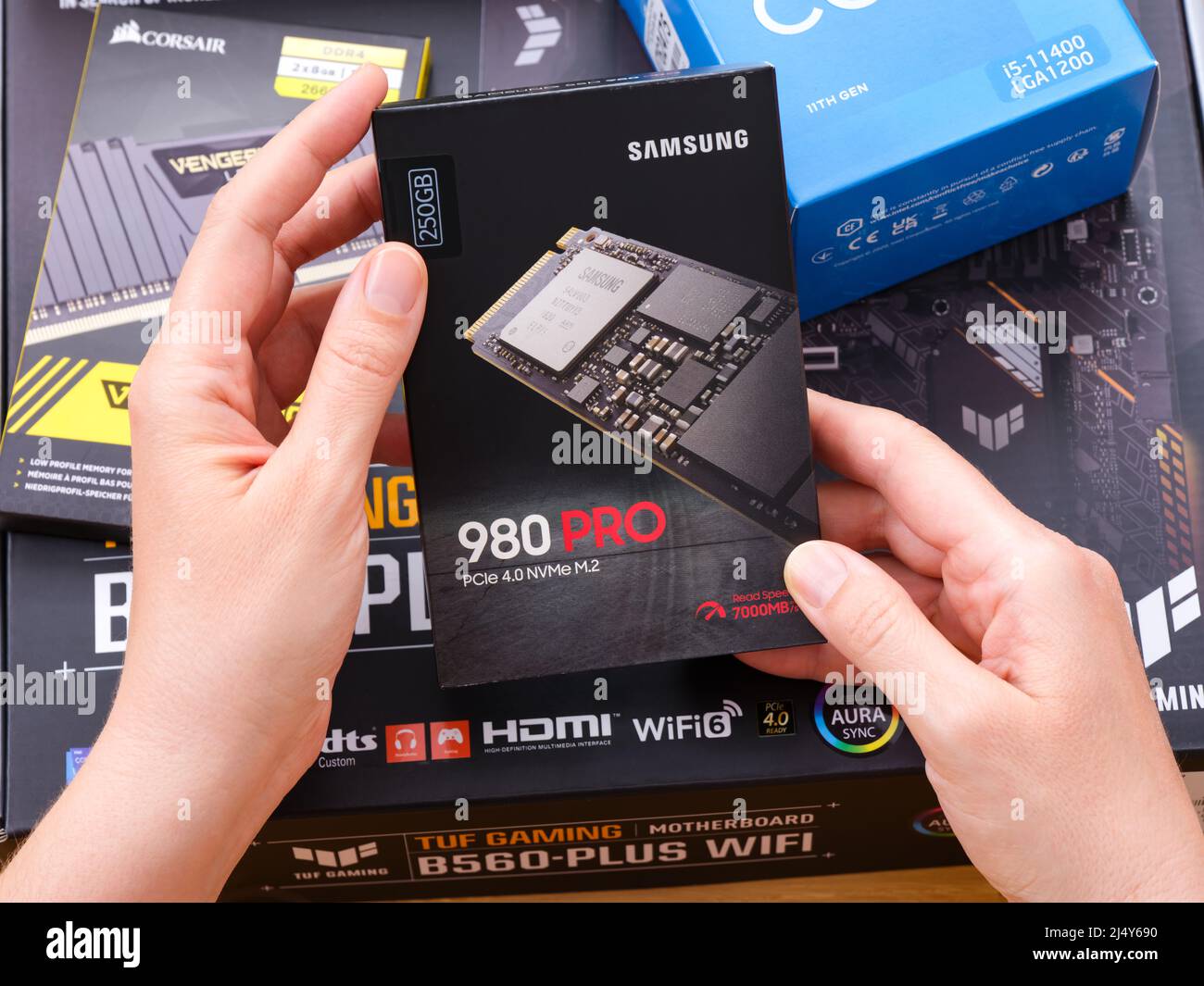 Tambow, Russische Föderation - 07. April 2022 Eine Frau hält eine Box mit einer Samsung SSD 980 pro m2 über andere Boxen mit brandneuen Komponenten in Th Stockfoto