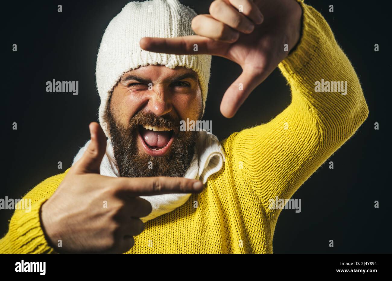 Bärtiger Mann macht Bilderrahmen mit Fingern. Fotoschild. Glücklicher Kerl zeigt Fotogesten. Stockfoto