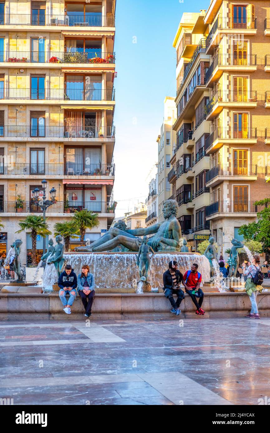 Touristen am Turia-Brunnen auf dem Platz der Jungfrau. Die Skulptur zeigt Neptun. Der Brunnen ist auch als Fuente del Tribunal De Aguas bekannt. I Stockfoto