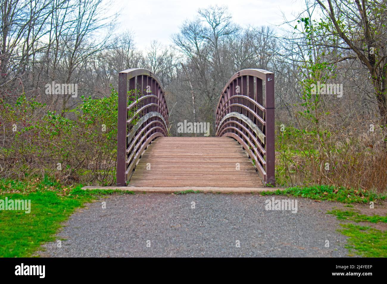 Fußgängerbrücke aus Stahl mit Holzsteg über einen schmalen Abschnitt des Delaware und Raritan Kanals im Colonial Park, Franklin, NJ, -12 Stockfoto