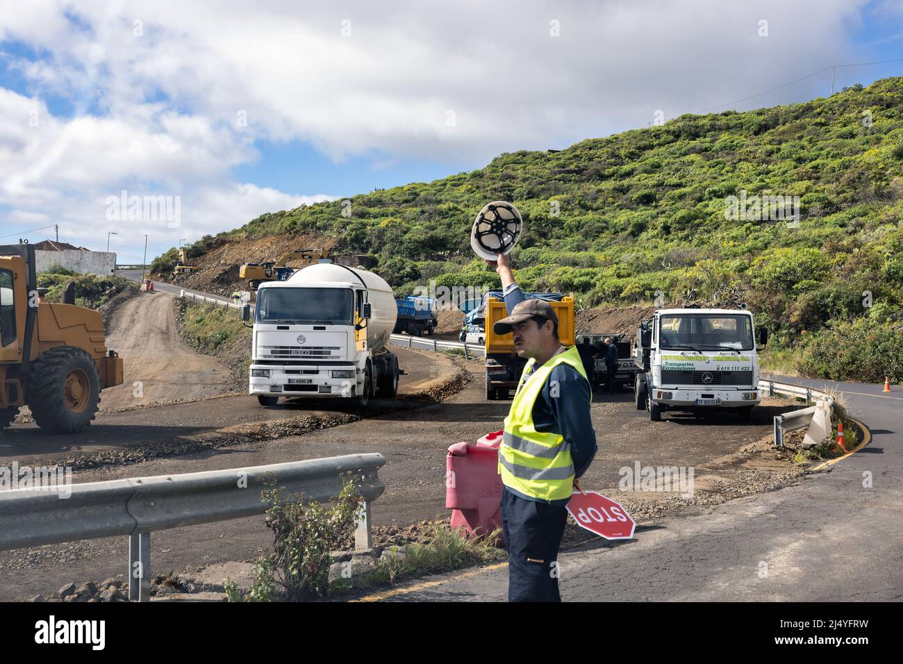 La Palma Island Spanien - 08. März 2022: Verkehrskontrolleur bei der Arbeit in der Nähe der Straße Baumaßnahmen mit schweren Geräten und Lastwagen Stockfoto