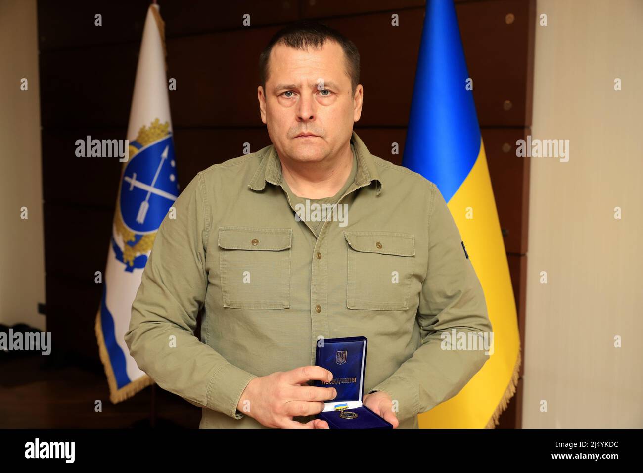 DNIPRO, UKRAINE - 14. APRIL 2022 - der Dnipro-Stadtchef Borys Filatov hält die Gedenkmedaille an den Verteidiger des Vaterlandes, die an NOR verliehen wird Stockfoto