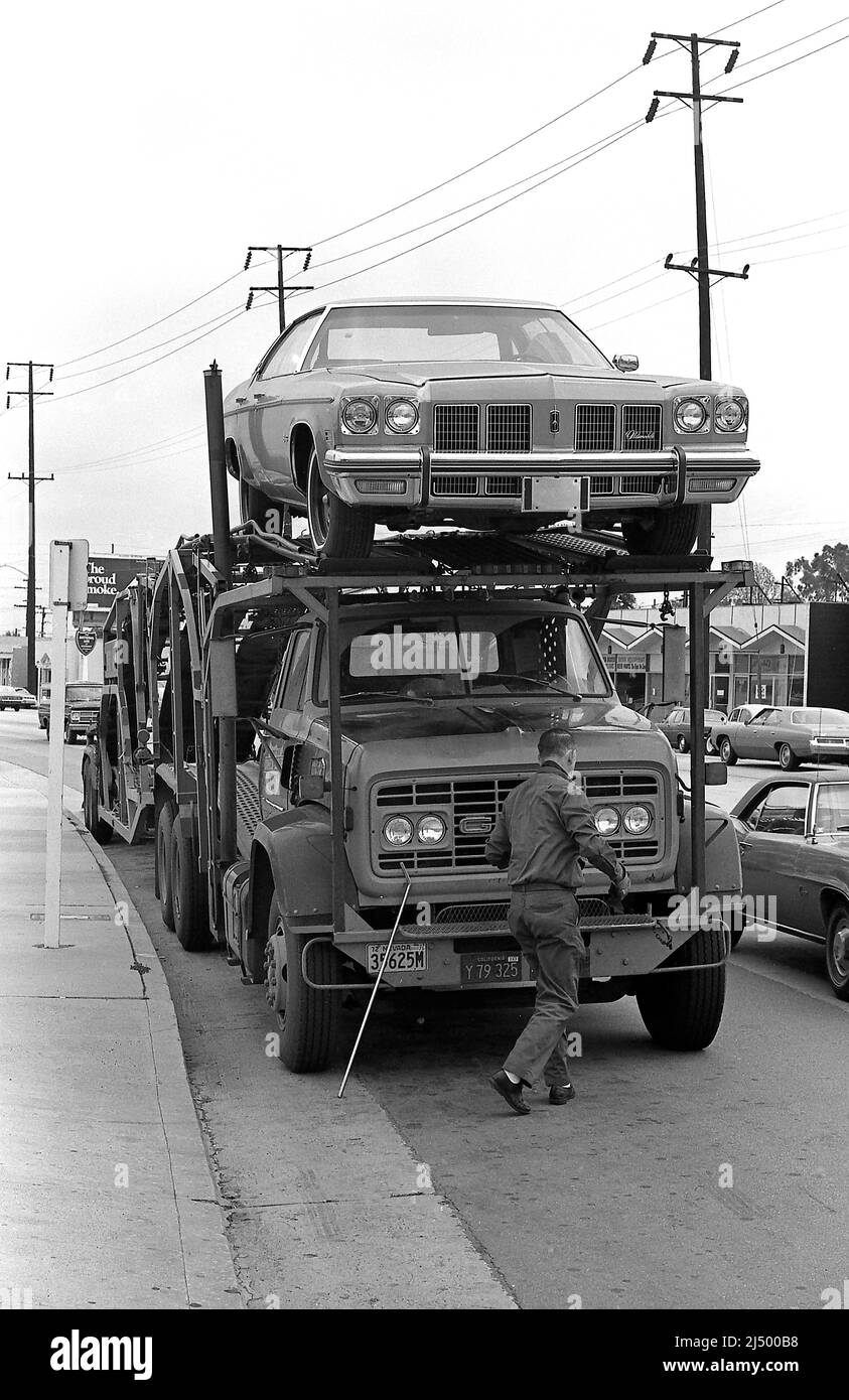 Großer LKW, der eine Oldsmobile Limousine an einen Händler in Los Angeles, CA 1976, liefert. Stockfoto