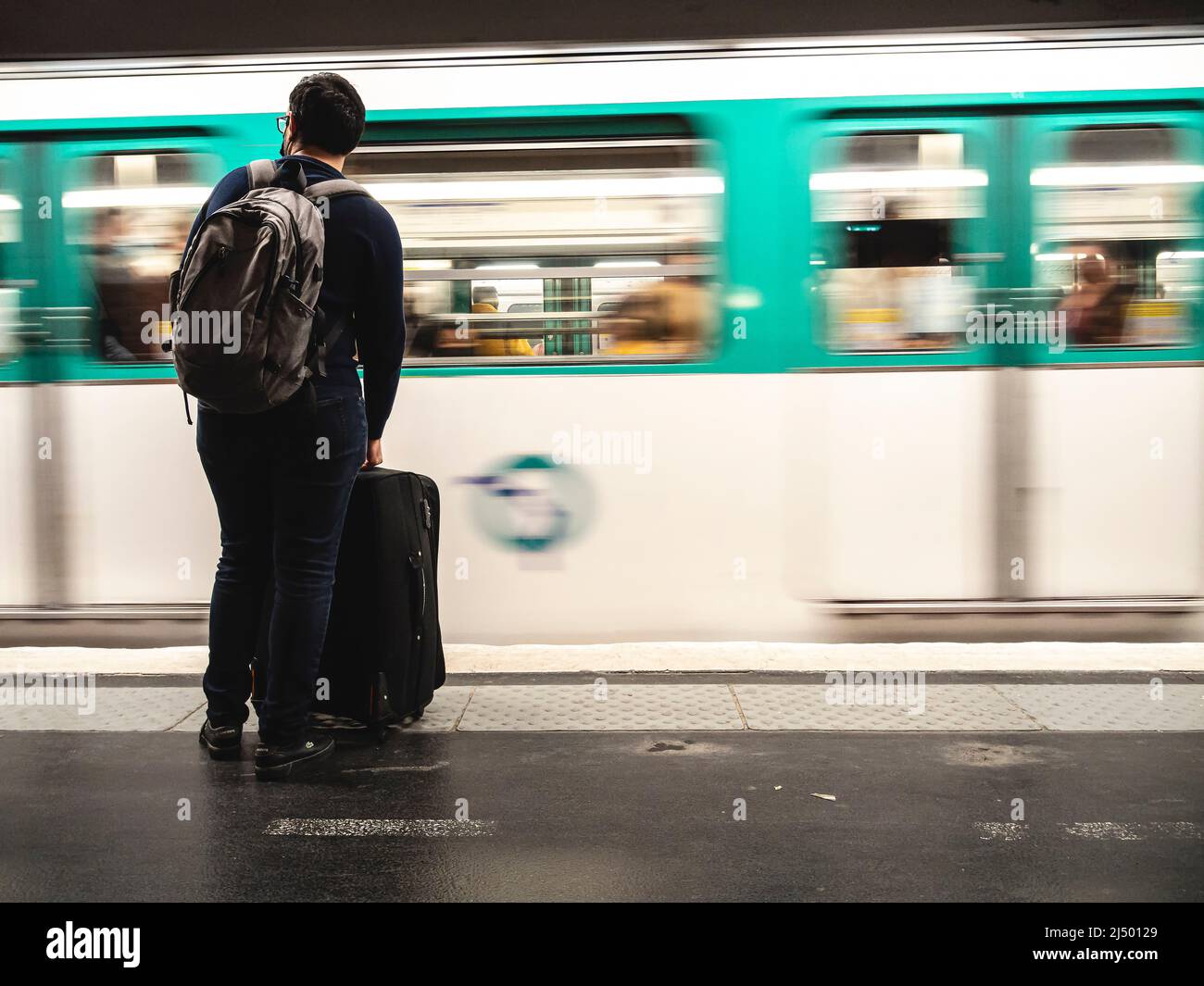 Ein Reisender, der an der U-Bahn-Haltestelle auf die Ankunft des Zuges wartet. Stockfoto