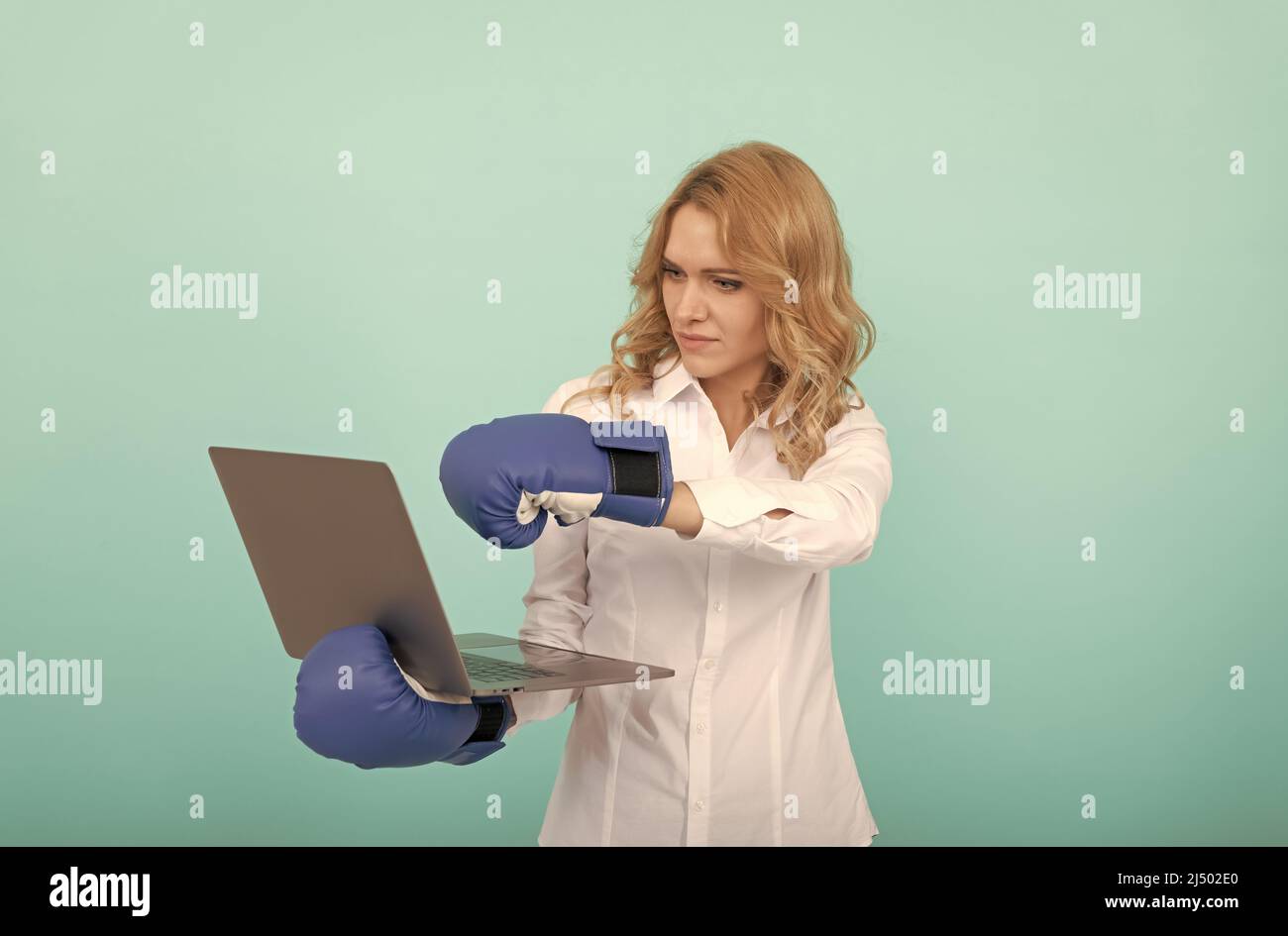 Frau Chef Punch Laptop in Boxhandschuhe. Wut Management. Cyber-Mobbing. Stockfoto