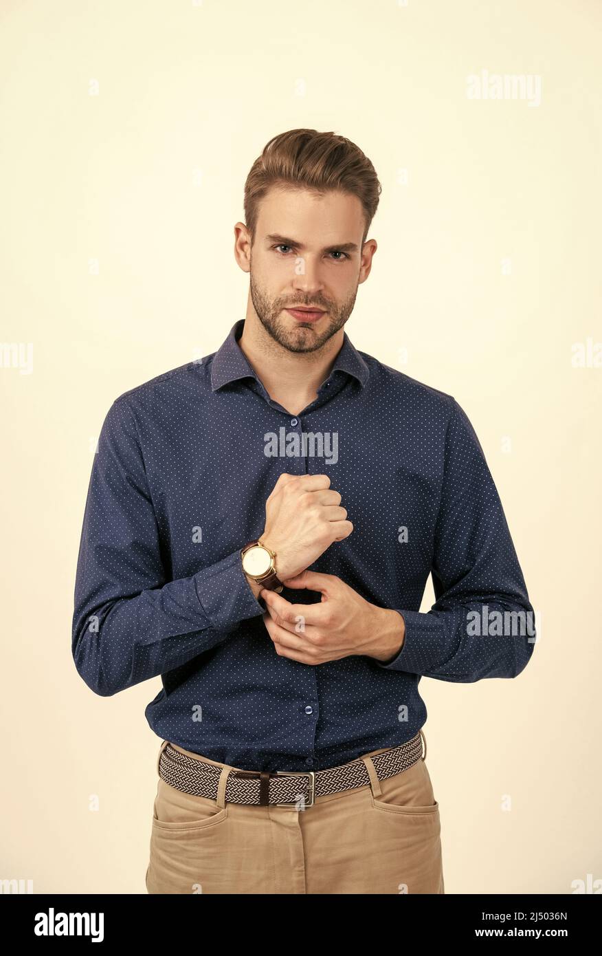 Schöner Mann mit stilvollen Haaren tragen Armbanduhr isoliert auf weißem, Mode-Accessoire Stockfoto