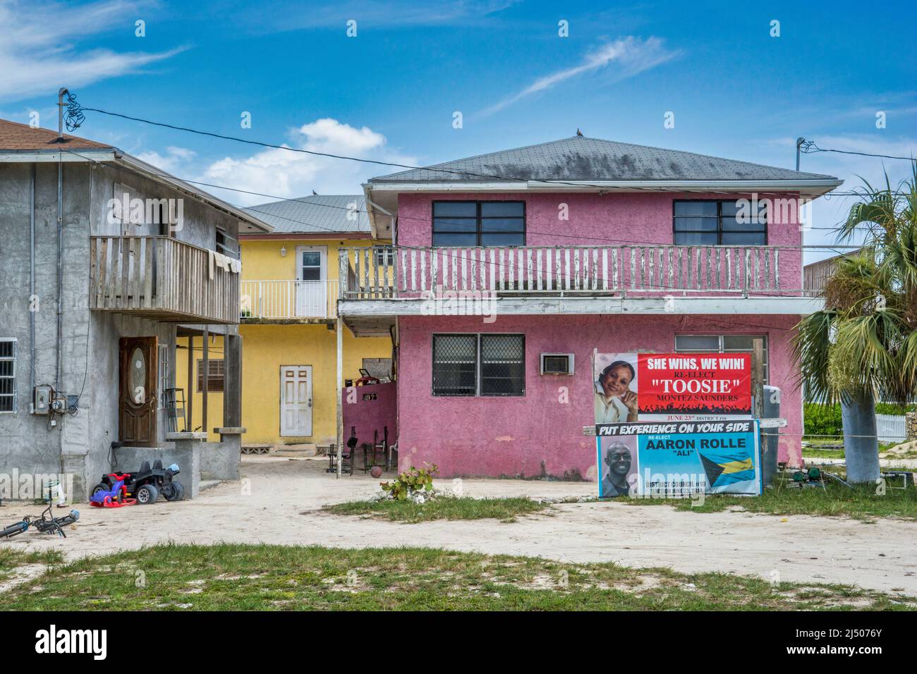 Wahlschilder vor zweistöckigen Häusern in Bimini, Bahamas. Stockfoto