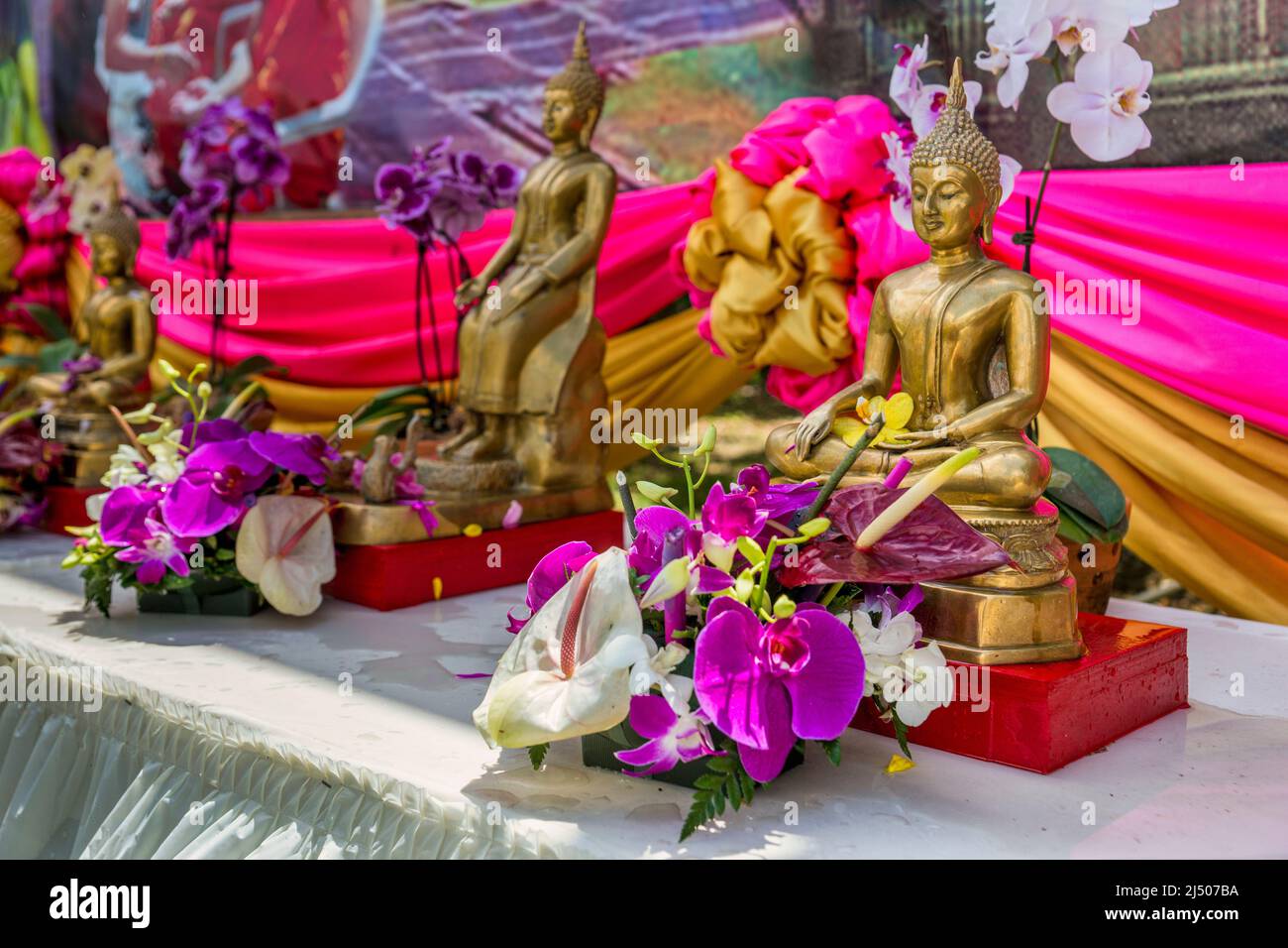 Buddha-Statuen mit Orchideen beim thailändischen Neujahrsfest im Wat Budharangsi in der Redland-Gegend von Miami-Dade County, Florida. Stockfoto