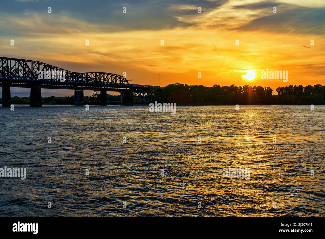 Die Sonne untergeht über der Küste von Arkansas an der Harahan Bridge am Mississippi River bei Memphis, Tennessee. Stockfoto