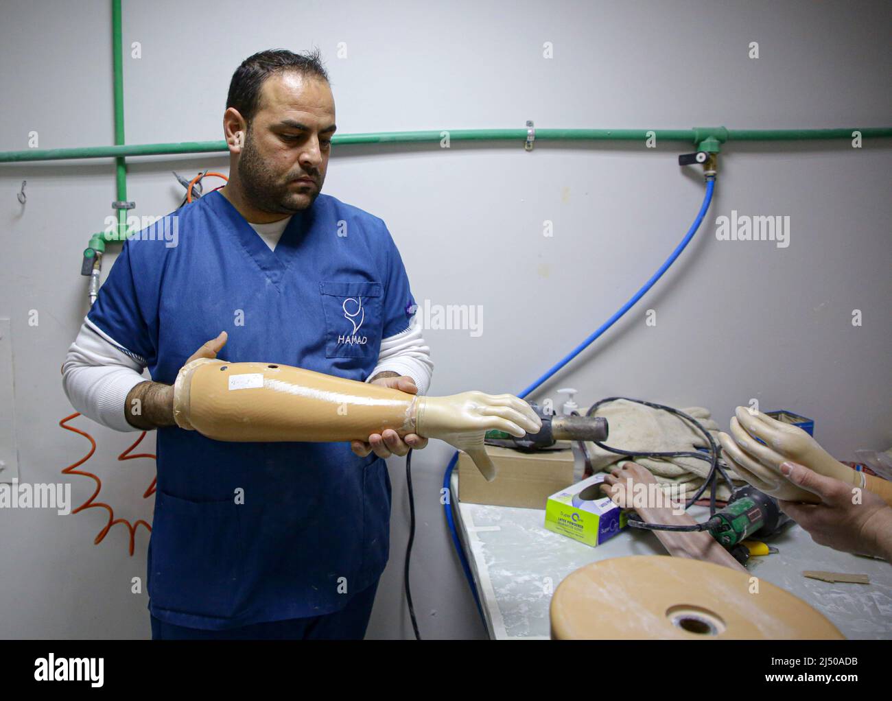 Gaza. 27. März 2022. Ein Arzt bereitet am 27. März 2022 im Krankenhaus zur Rehabilitation und Prothetik von Sheikh Hamad bin Khalifa Al Thani in Gaza-Stadt eine künstliche Extremität vor. Das Krankenhaus gilt als das einzige in Gaza, das sich auf die Produktion und Anpassung der oberen Extremitäten spezialisiert hat."Feature: Bionic Hand hilft behinderten Menschen im Gazastreifen, wieder Hoffnung zu erlangen" Quelle: Rizek Abdeljawad/Xinhua/Alamy Live News Stockfoto