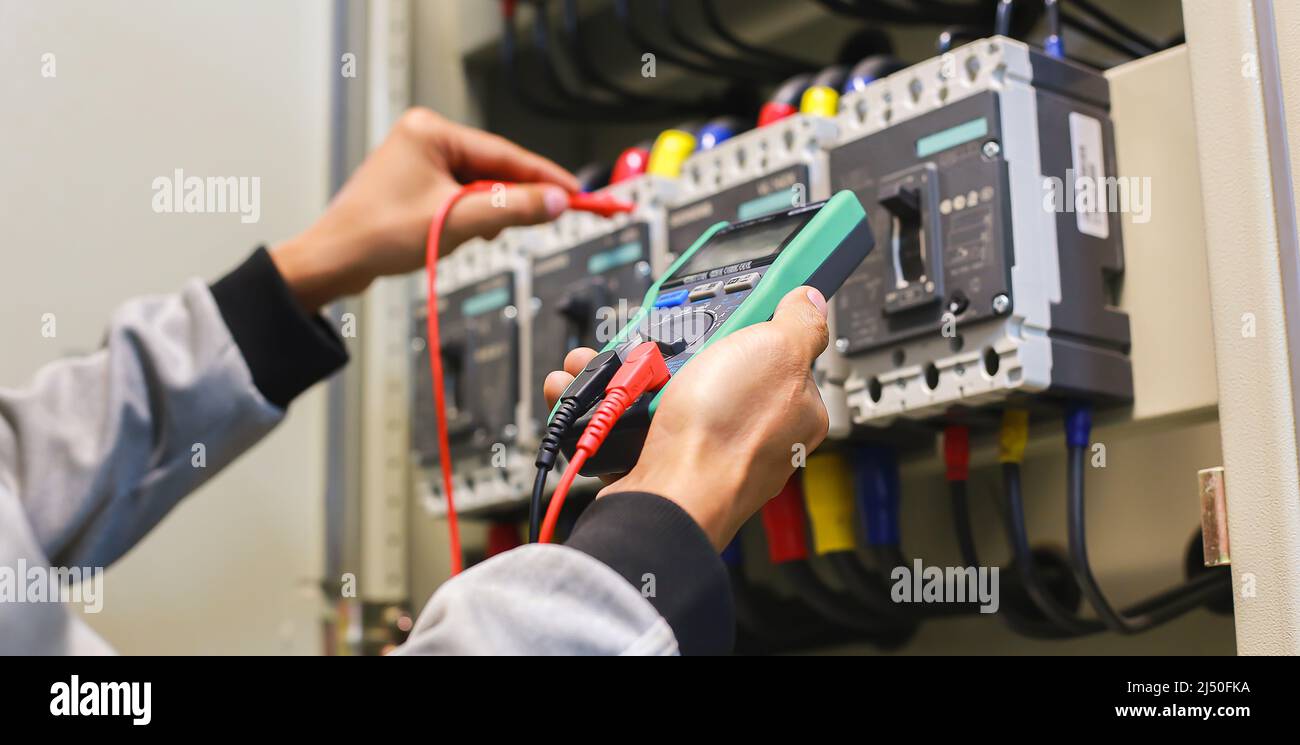 Ein Elektroingenieur überprüft die Funktion des Schaltschranks. Stockfoto