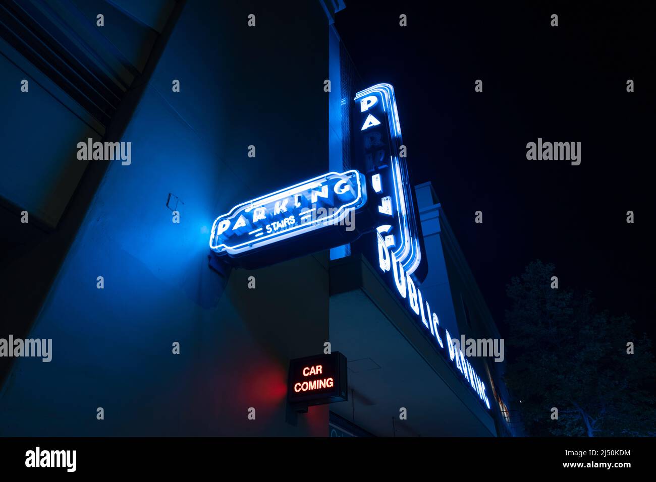 Nachts sind die Schilder für öffentliche Parkplätze im Art déco-Stil in Neon angebracht Stockfoto