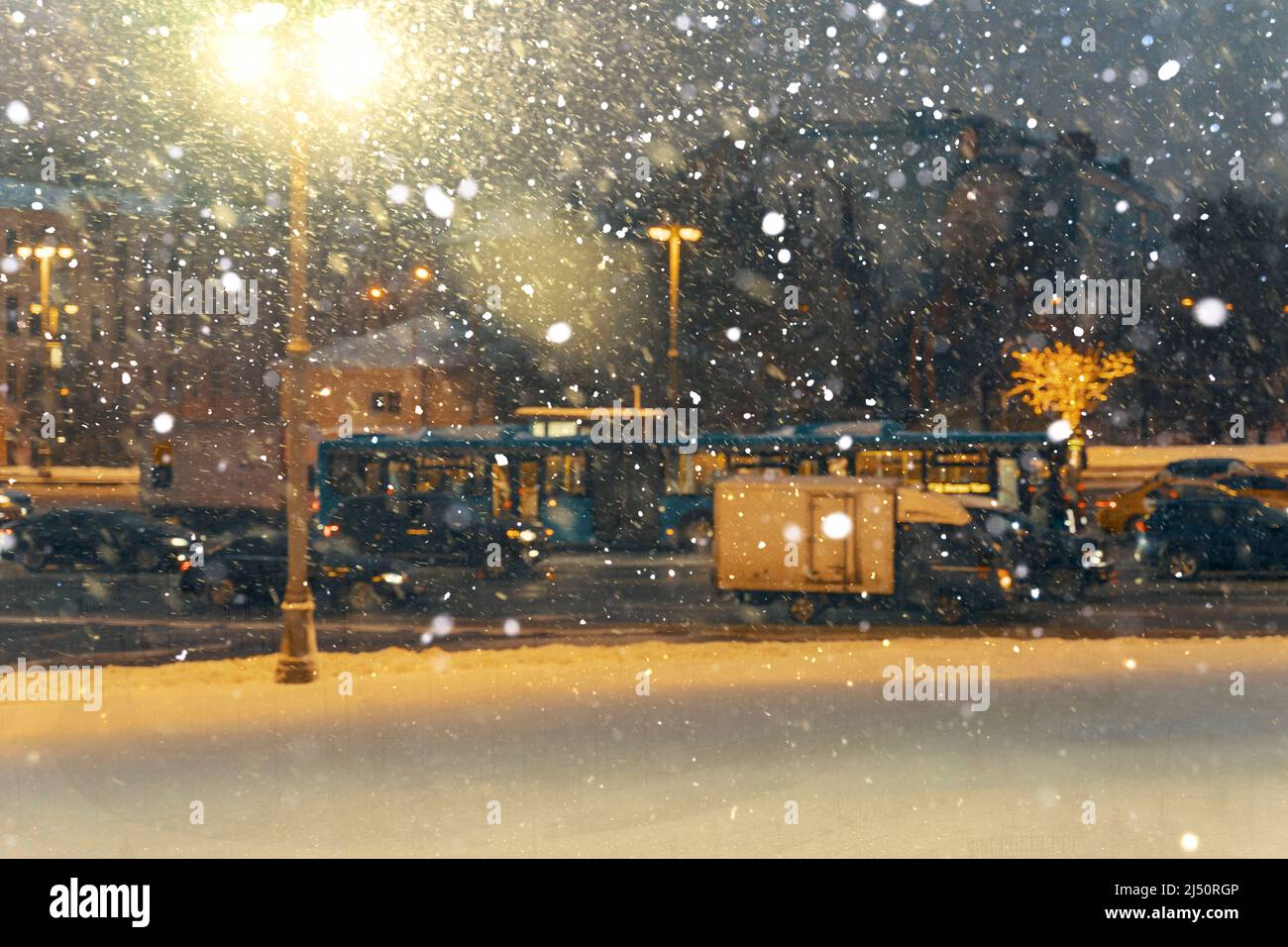 Schlechtes Wetter in Moskau. Starker Schneefall und Wind, schlechte Sicht. Eine Straßenlampe beleuchtet einen Schneesturm. Straßenverkehr Stockfoto