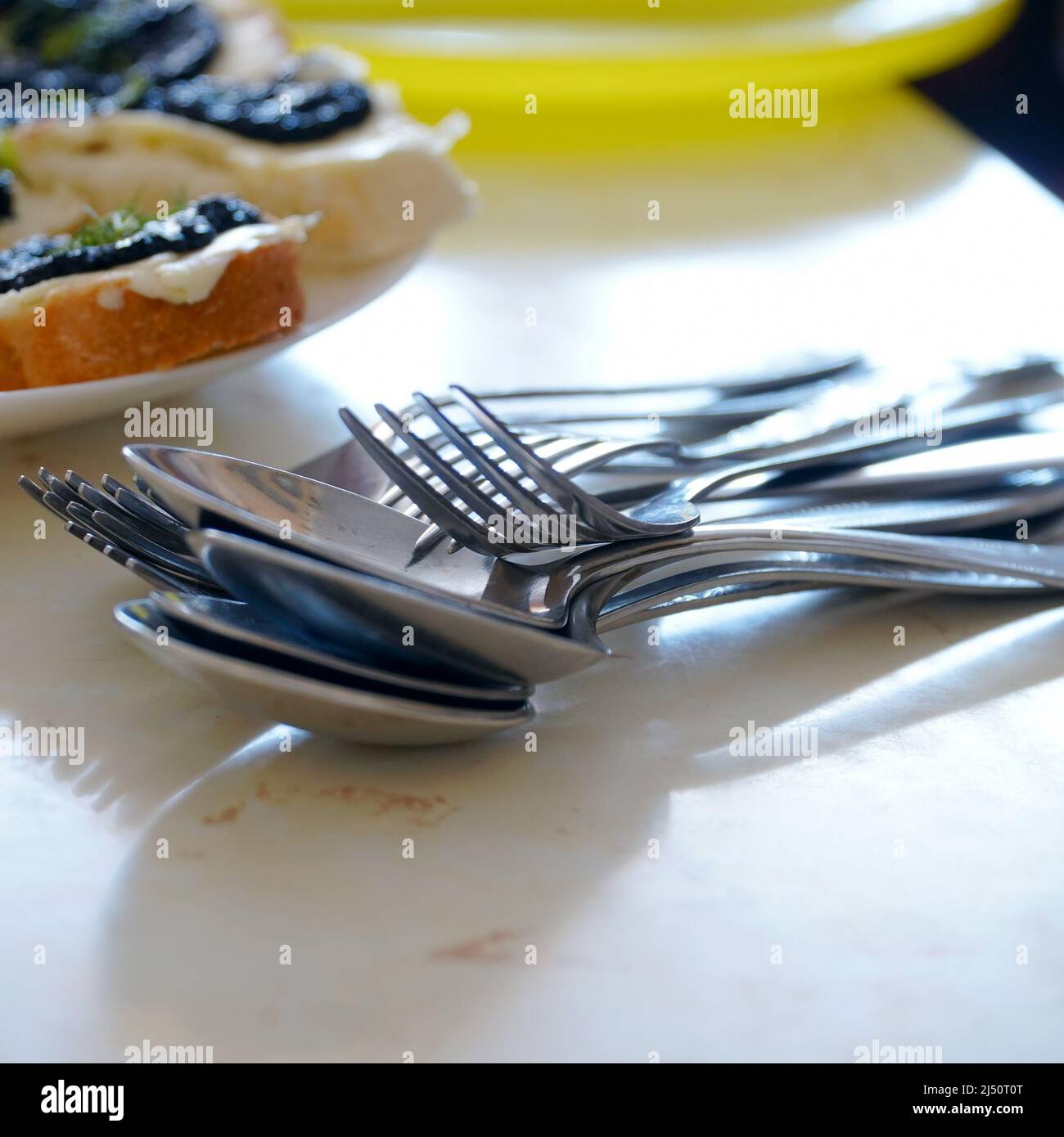 Metalllöffel und Gabeln in einem Stapel auf dem Tisch. Selektiver Fokus Stockfoto