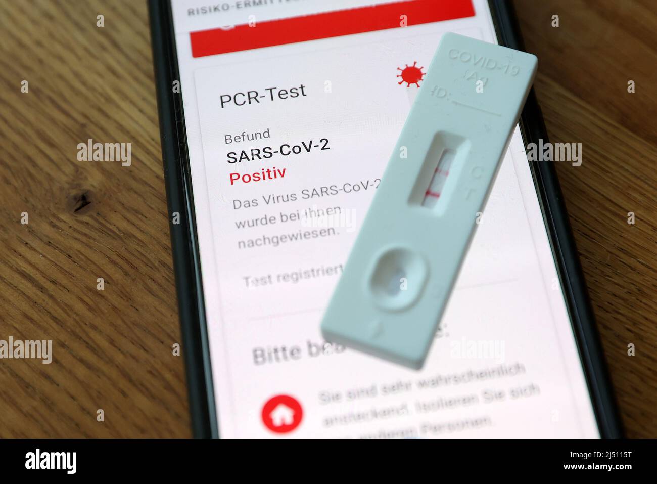 Hamburg, Deutschland. 18. April 2022. Ein positiver Schnelltest wird auf einem Mobiltelefon durchgeführt und ein positiver PCR-Test wird in der Corona Alert App angezeigt. Kredit: Bodo Marks/dpa/Alamy Live Nachrichten Stockfoto