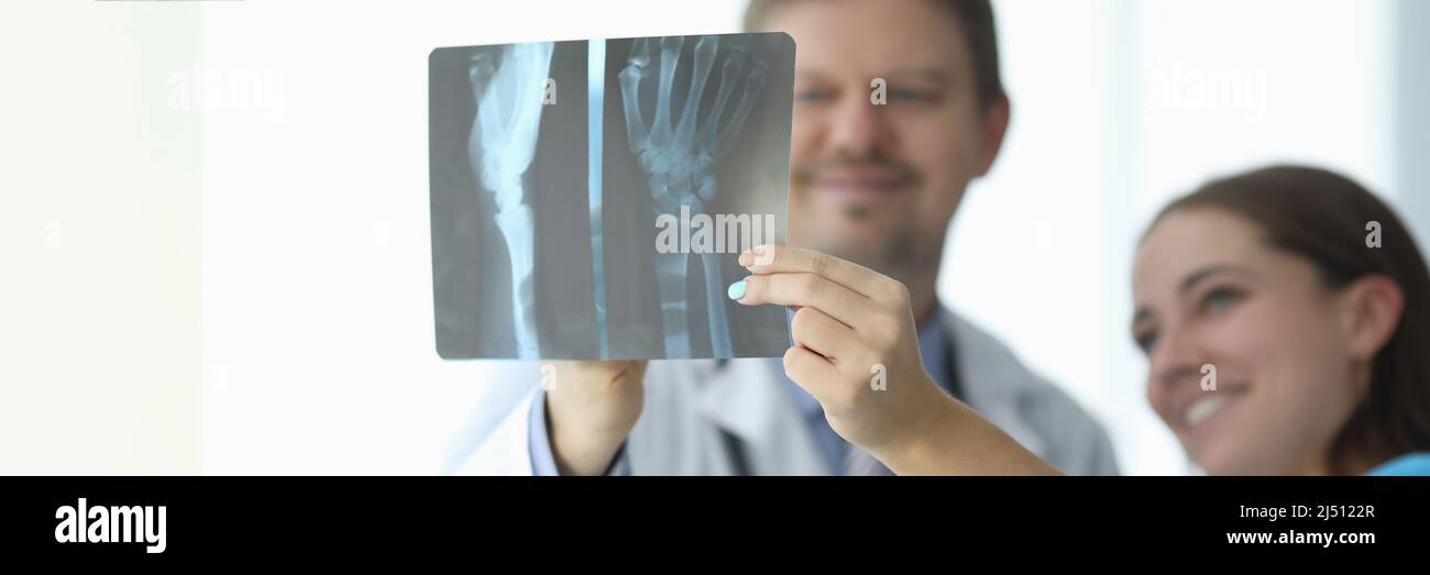 Ärzte betrachten den Röntgenstrahl der Hand in der Klinik Nahaufnahme Stockfoto