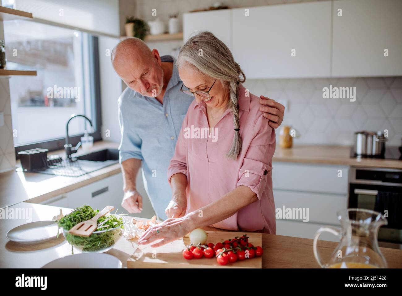 Glückliches Seniorenpaar, das zu Hause zusammen kocht. Stockfoto