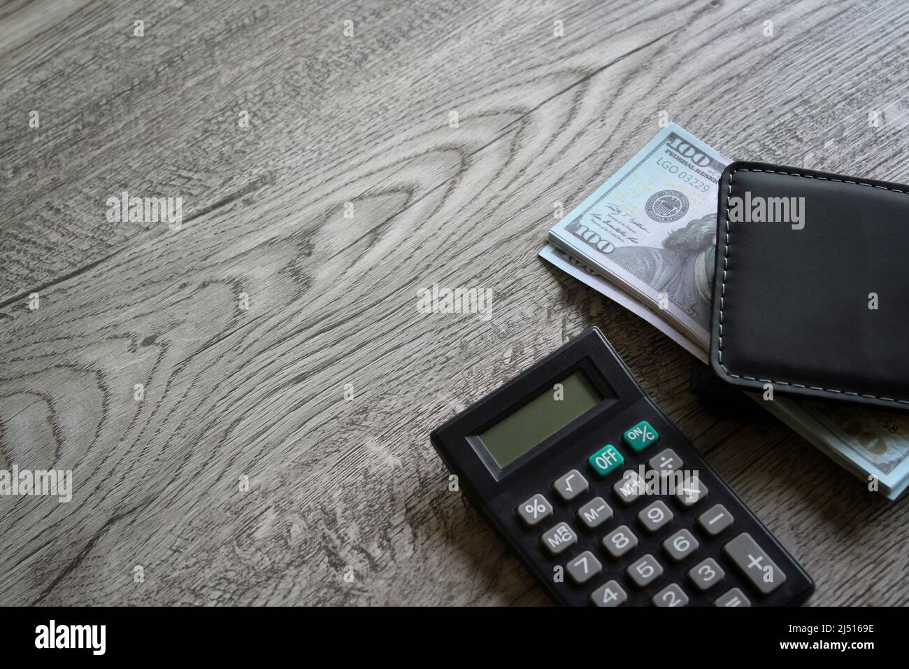 Taschenrechner, Geldbörse und Geld auf Holztisch mit Kopierplatz. Geschäfts- und Finanzkonzept Stockfoto