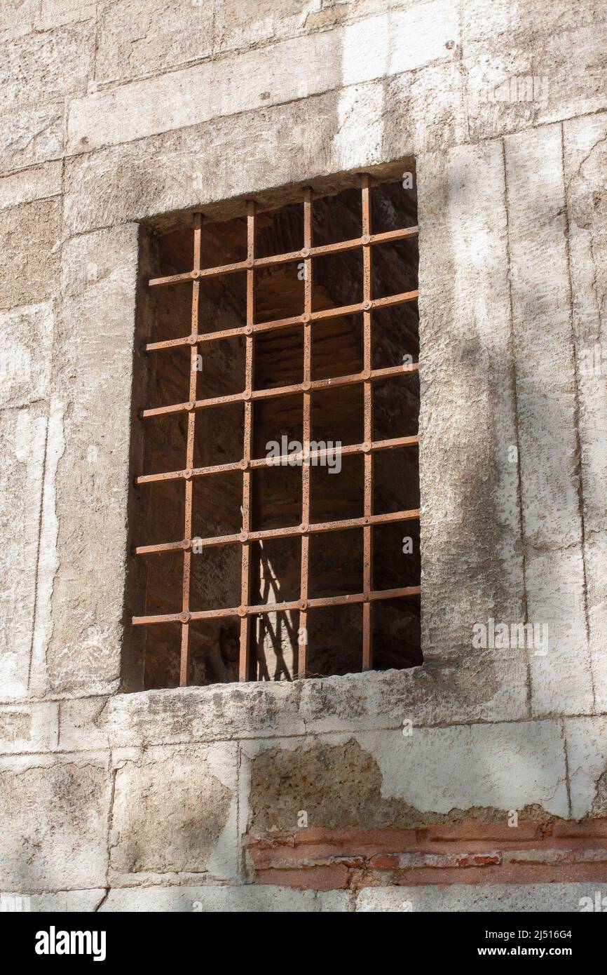 Geschmiedetes antikes Gitter am Fenster in dicker Wand. Stockfoto