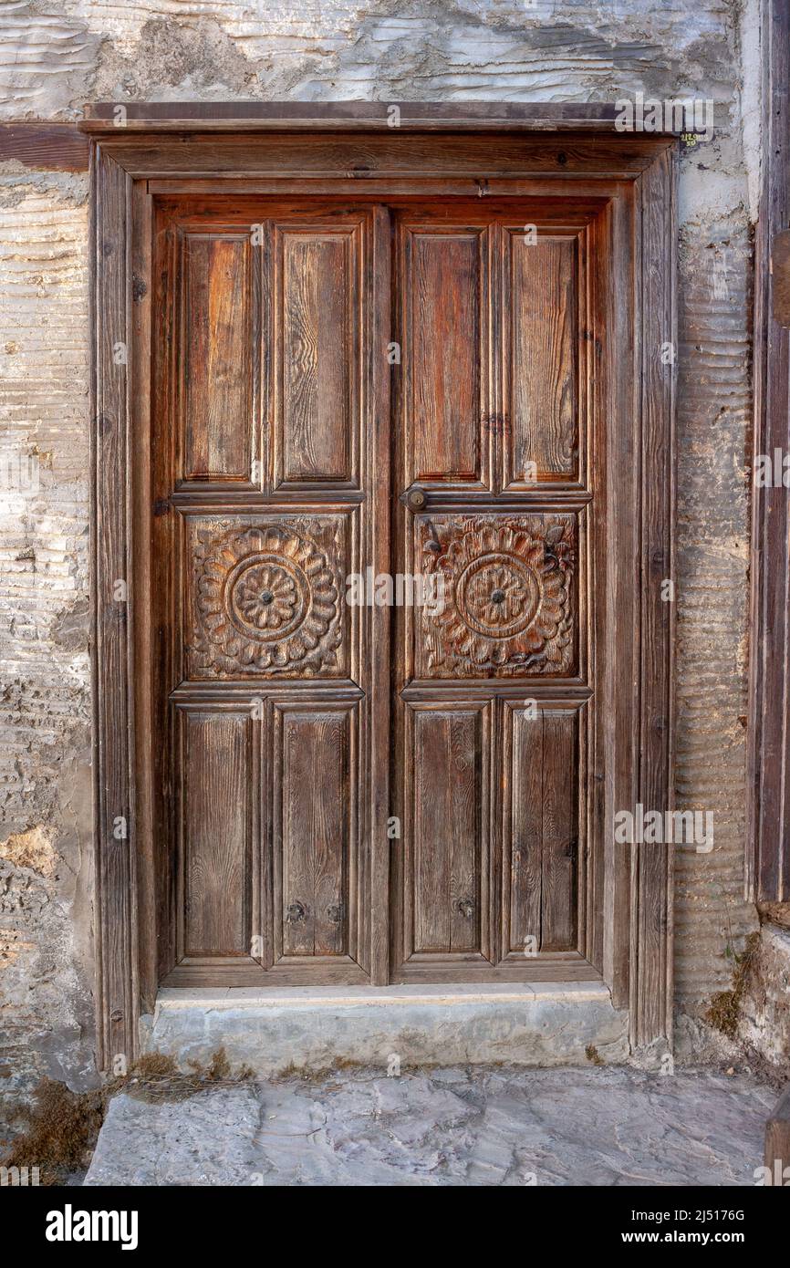 Alte, schäbig geschnitzte Holztür. Stockfoto