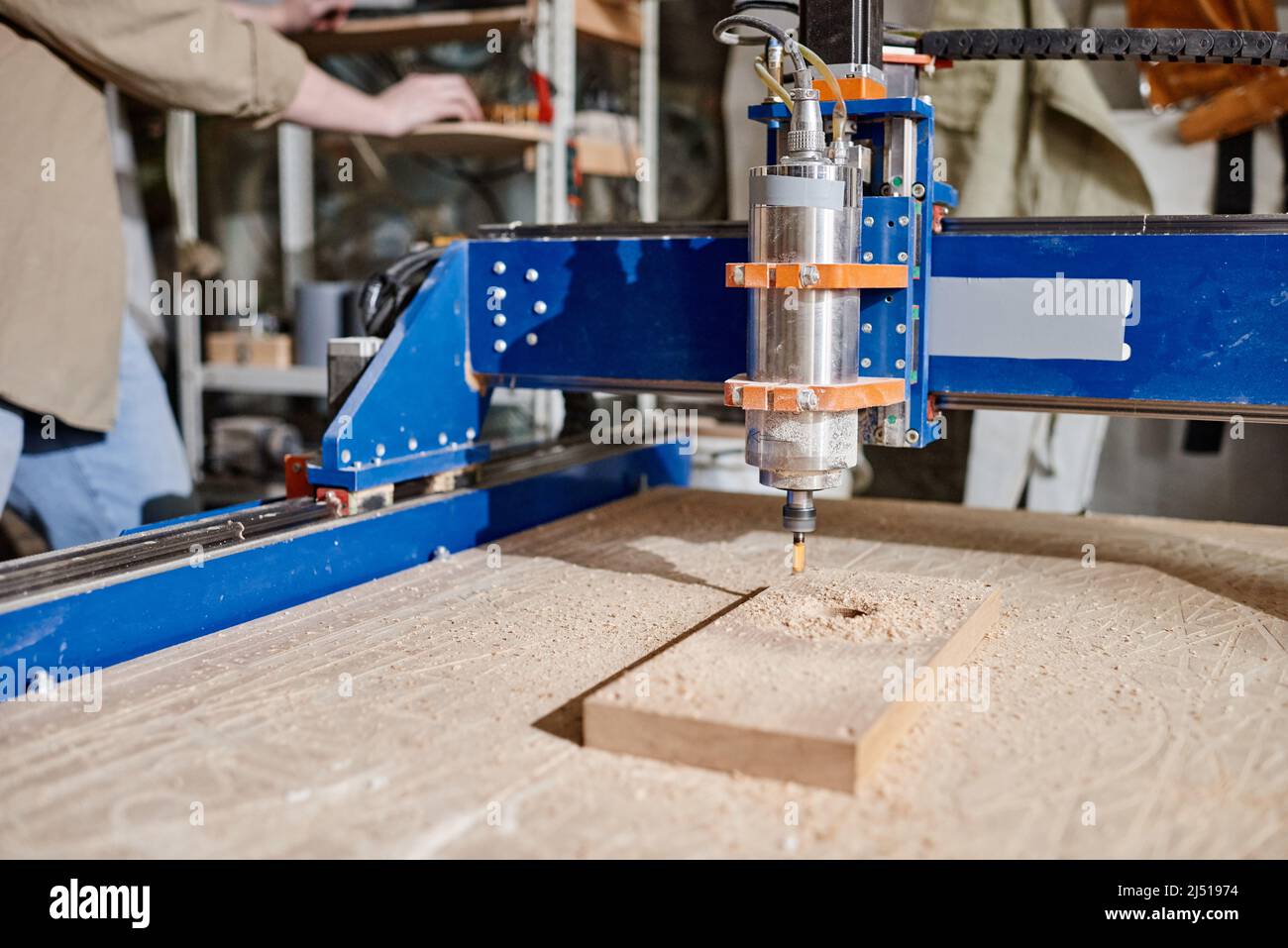 Nicht erkennbarer Zimmermann, der CNC-Fräsmaschine bediente, um Löcher in Holzblock zu machen, mittlere Nahaufnahme Stockfoto