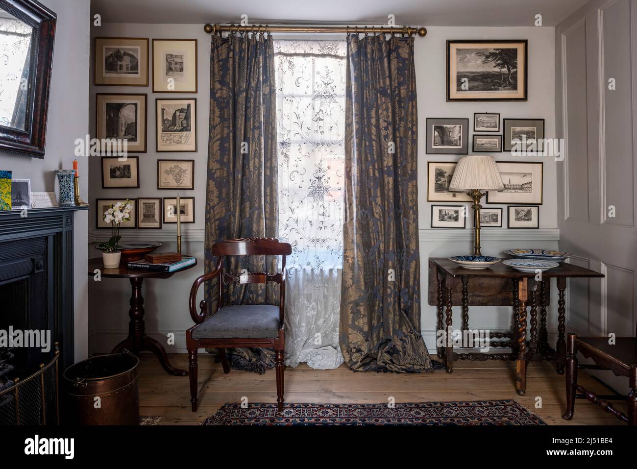 Antike Damastvorhänge auf viktorianischer Stange mit Vintage-Spitzenplatte und antiken Möbeln in Grade II gelistet 1820s London Cottage, UK Stockfoto