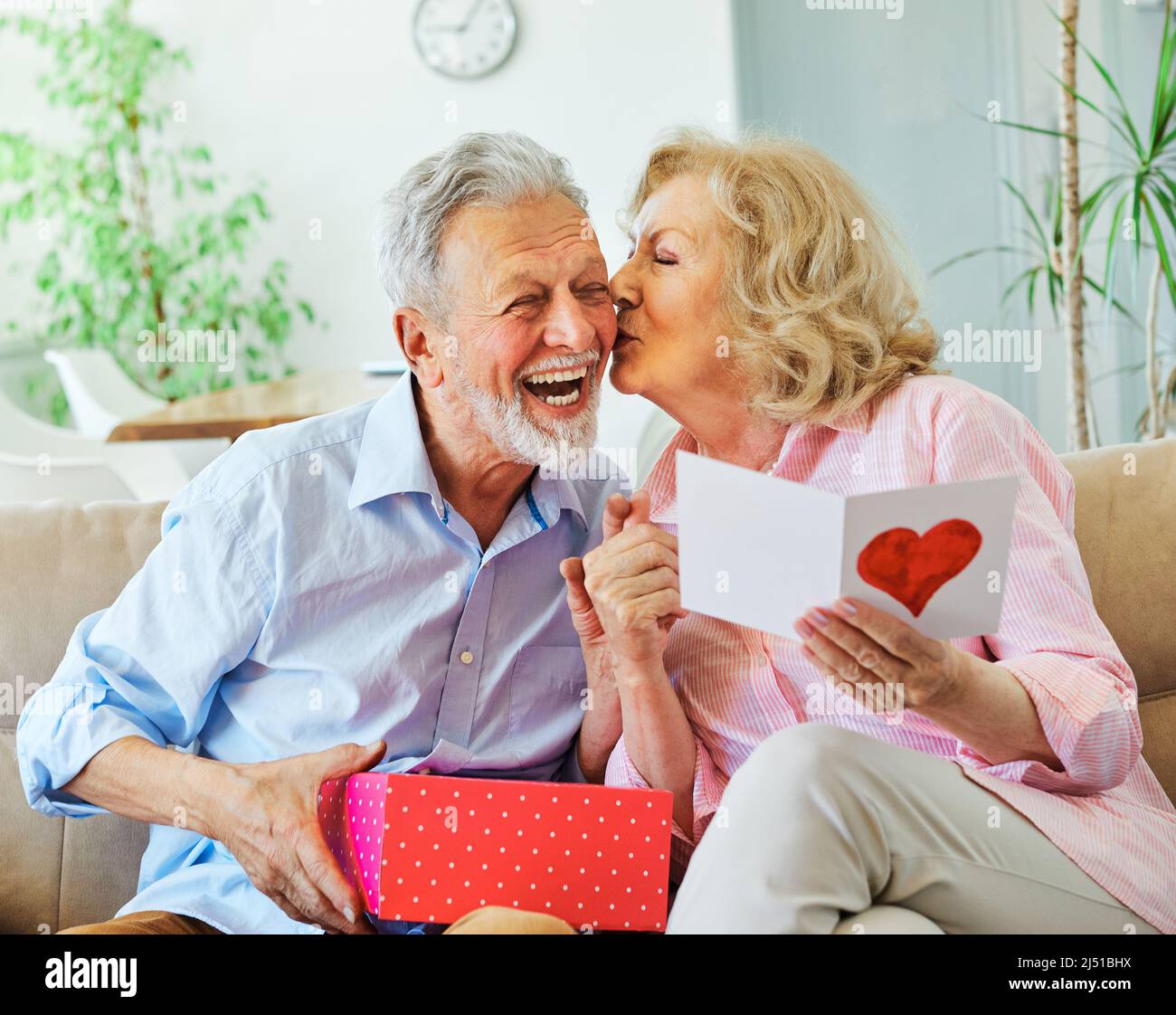Geschenk Frau Mann Paar glücklich Liebe Glück Geschenk Kuss romantisch lächelnd zusammen Box Frau Mann ältere ältere ältere ältere ältere Rentner Stockfoto