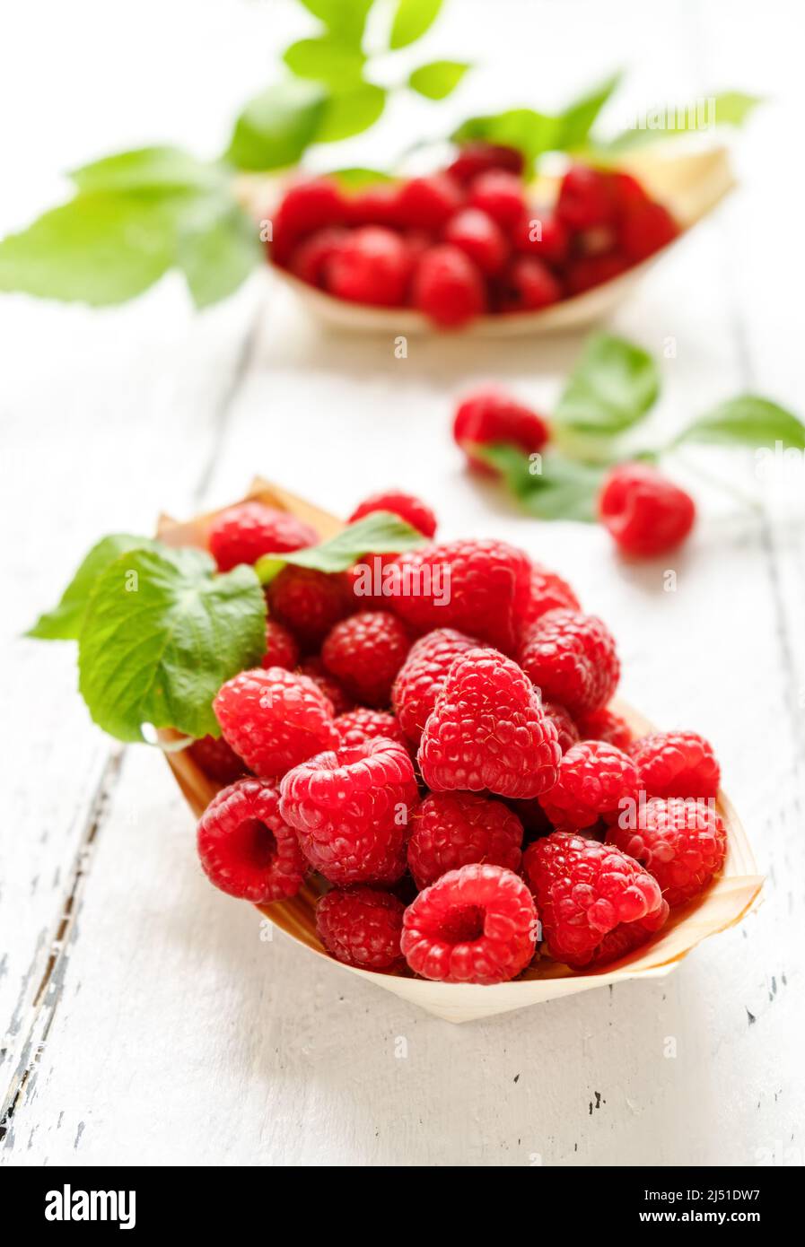 Himbeeren in den Holzplatten - Boote mit Blättern Stockfoto