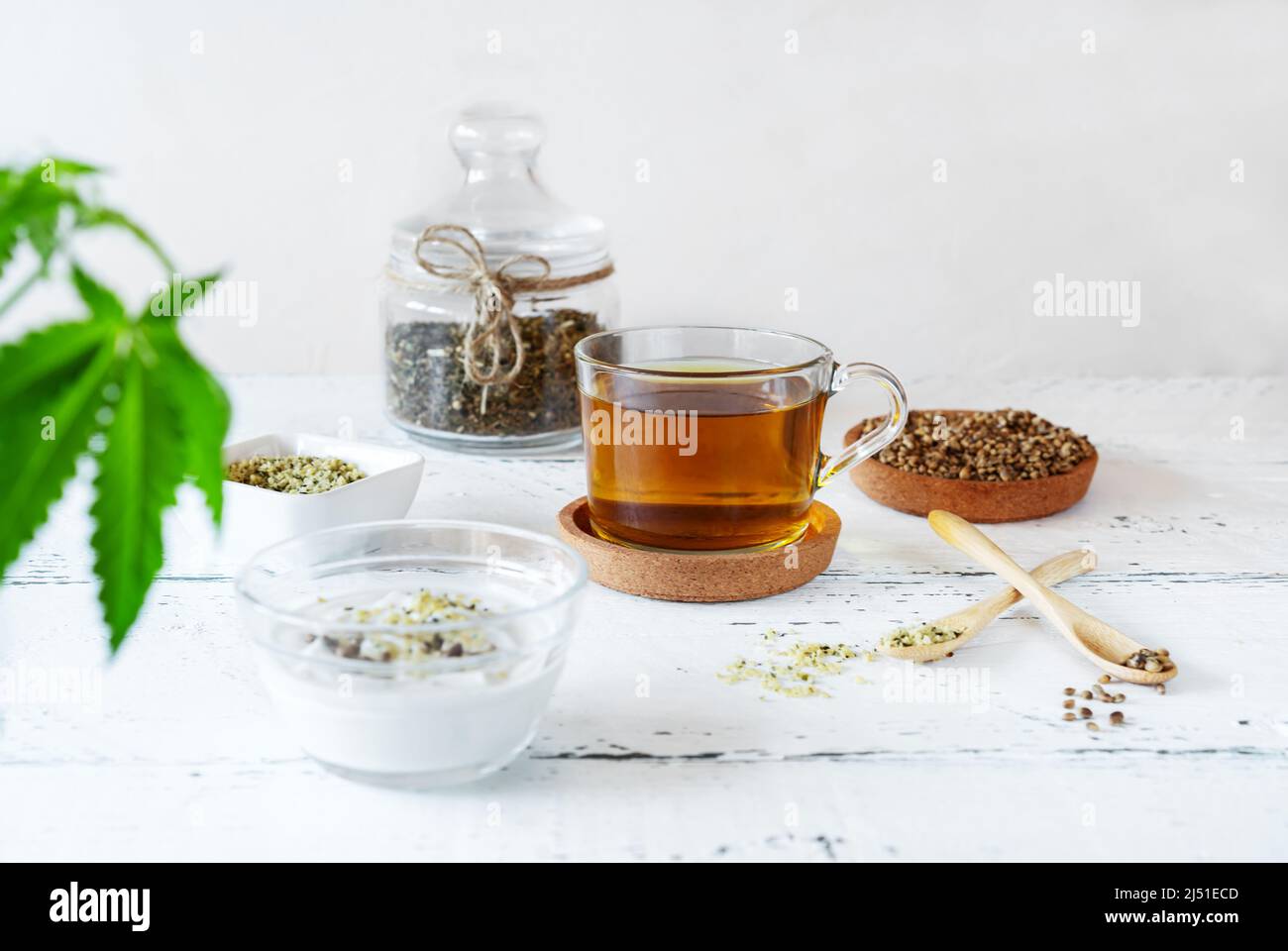 Hanfprodukte: Tee, geschälte und ganze Samen, Joghurt mit Samen, Cannabispflanze Stockfoto