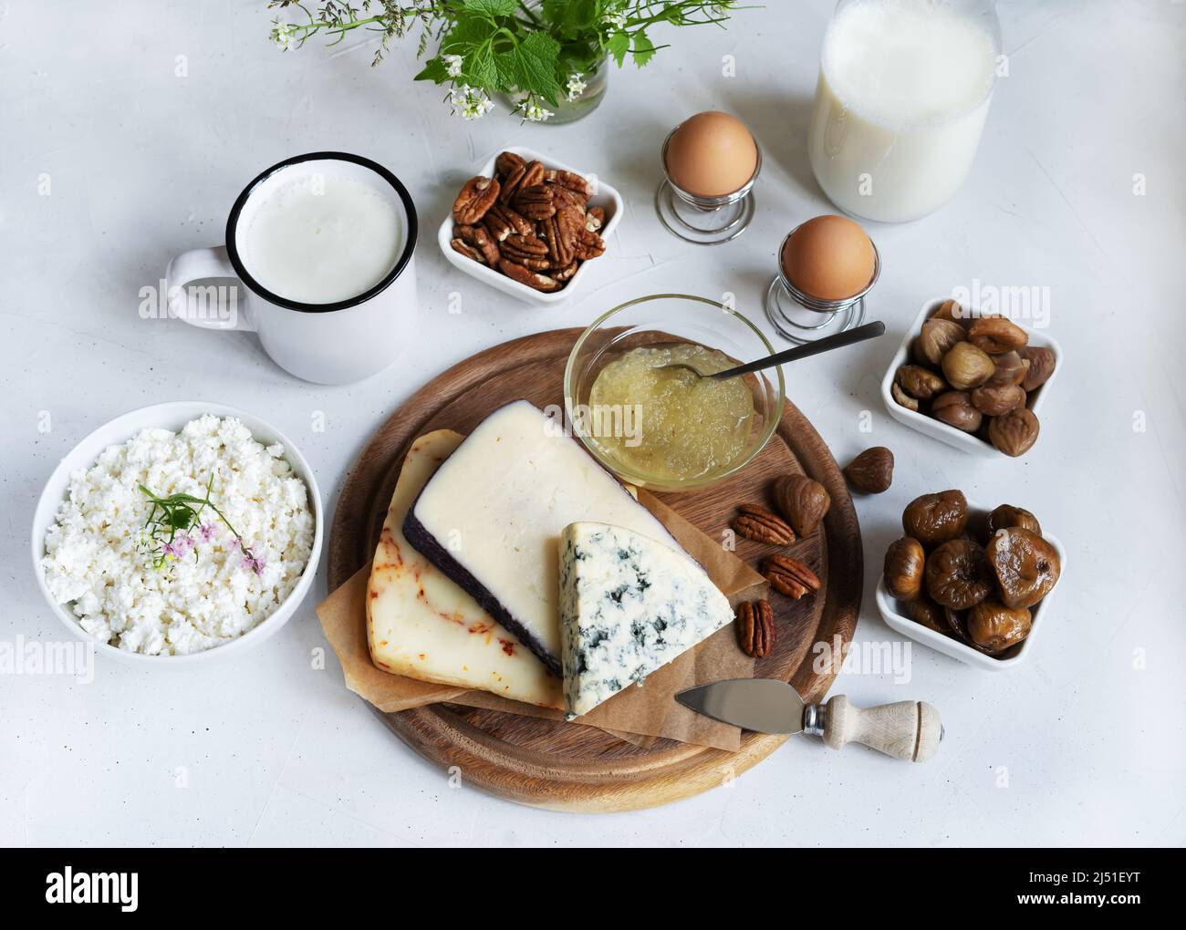 Käseplatte mit Birnensauce, Milchglas, Kefir, Quark, Nüsse auf dem hellen Hintergrund Stockfoto