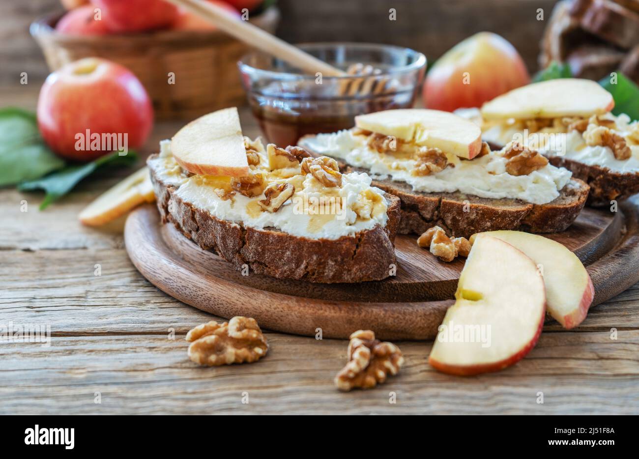Brotscheiben mit Quark, Honig, Äpfeln und Nüssen Stockfoto