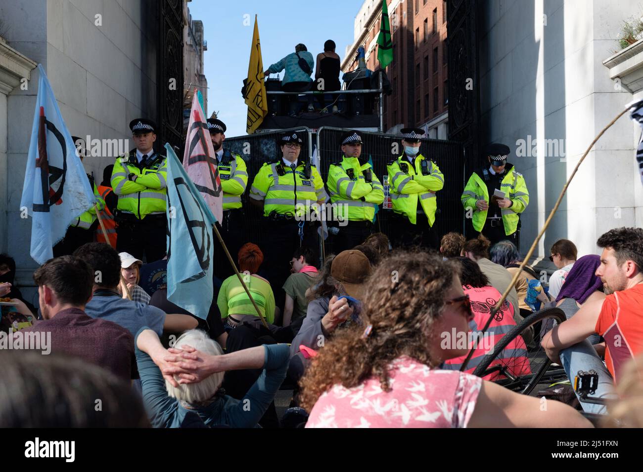 London, Großbritannien. 16. April 2022. Extinction Rebellion (XR)-Aktivisten sprangen auf eine Schwarze Limousine und saßen auf dem Boden und klebten sich in Marble Arch. Später wurde ein Transparent mit der Aufschrift ‘'Stop fossile Brennstoffe now' auf den Bogen gesetzt. Der heutige Tag war Teil einer einwöchigen Welle von Protesten und zivilen Ungehorsamsmaßnahmen, die die britische Regierung angesichts der Klimakrise und der ökologischen Notlage dazu aufforderte, die gesamte neue Infrastruktur für fossile Brennstoffe sofort zu stoppen. Stockfoto