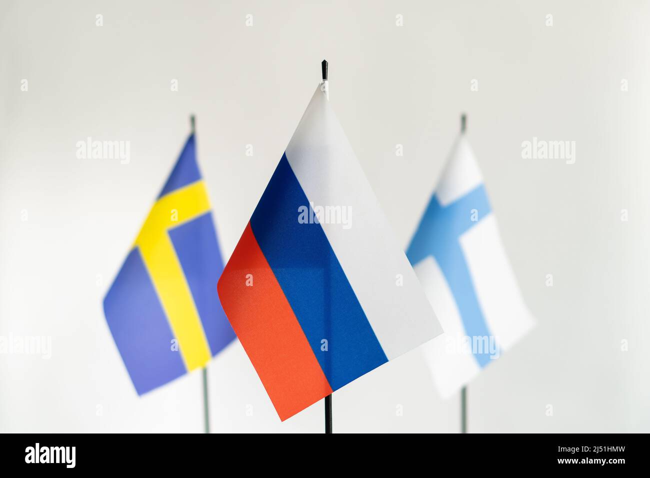 Staatsflagge Russlands im Fokus und Schwedens Finnlands auf weißem Hintergrund. Konflikt, Partnerschaftskonzept Stockfoto