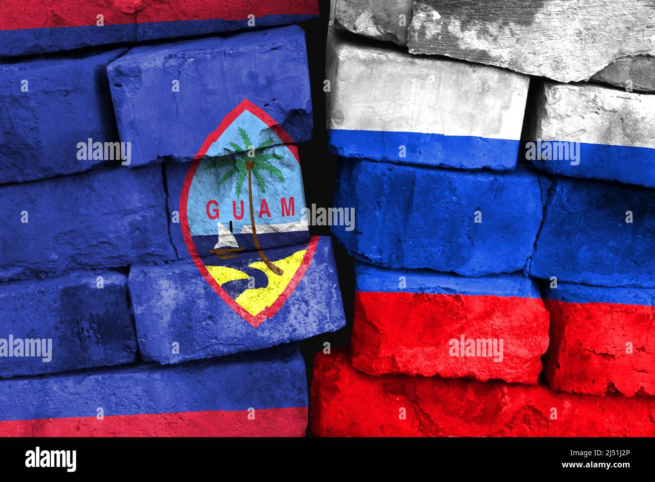 Konzept der Beziehung zwischen Guam und Russland mit zwei bemalten Fahnen auf einer beschädigten Ziegelwand Stockfoto