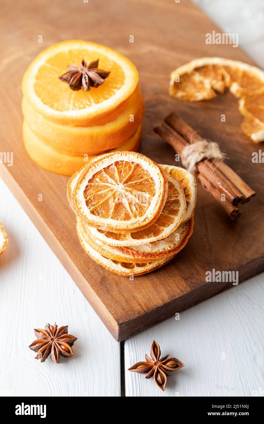 Getrocknete Orangenscheiben, Zimt und Sternanise auf Holzbrett. Stockfoto