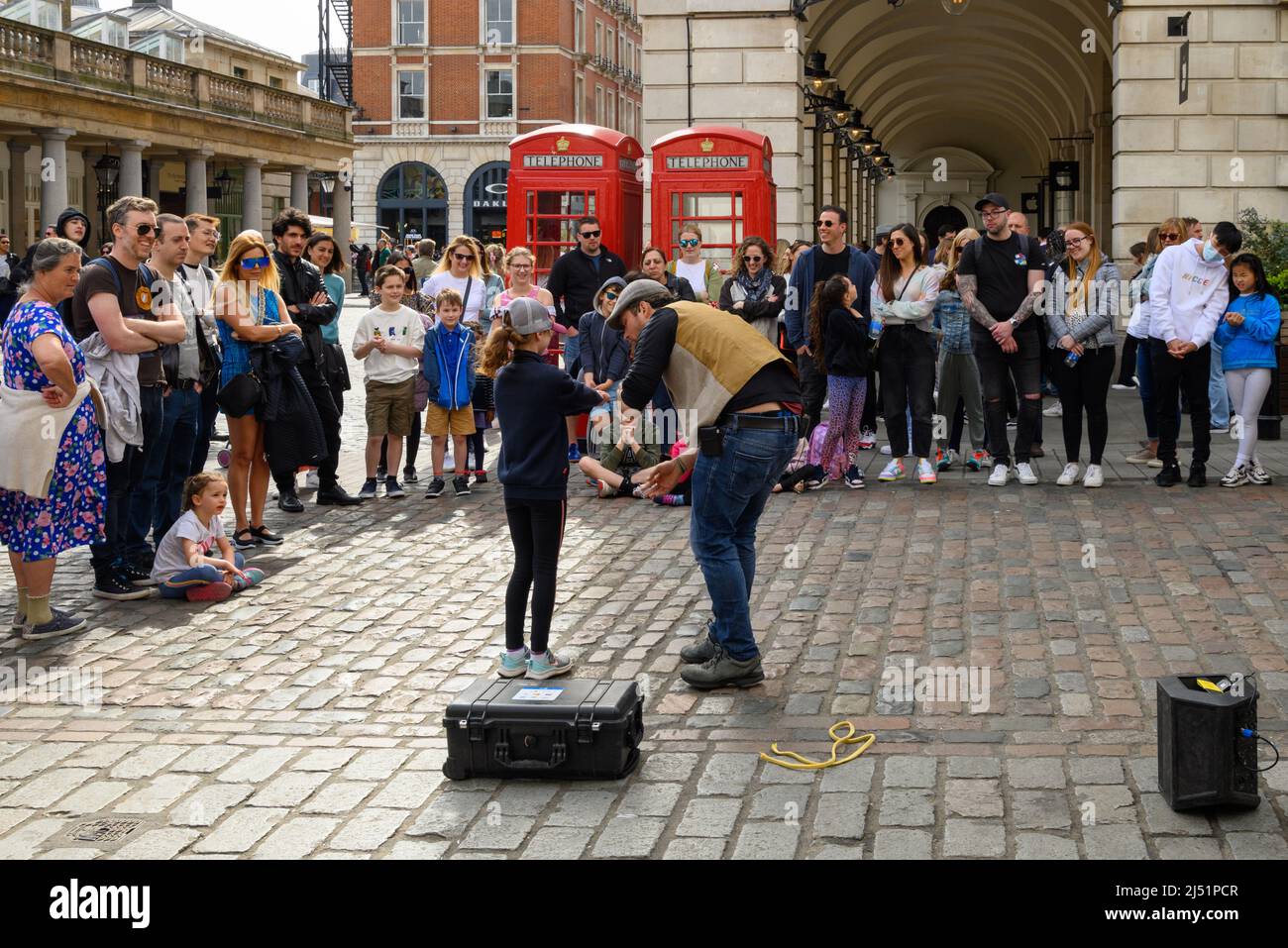 Straßenkünstler, der im April in Covent Garden, London, Großbritannien, für Menschenmengen auftrat Stockfoto