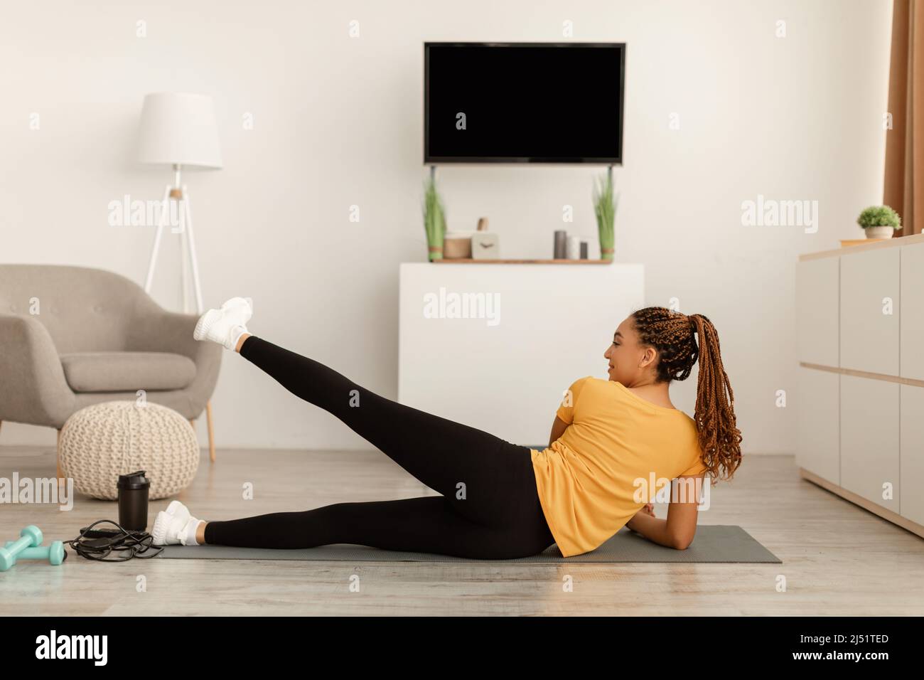 Schwarzes Weibchen Macht Seitliches Bein Hebt Liegend Training Zu Hause An Stockfoto