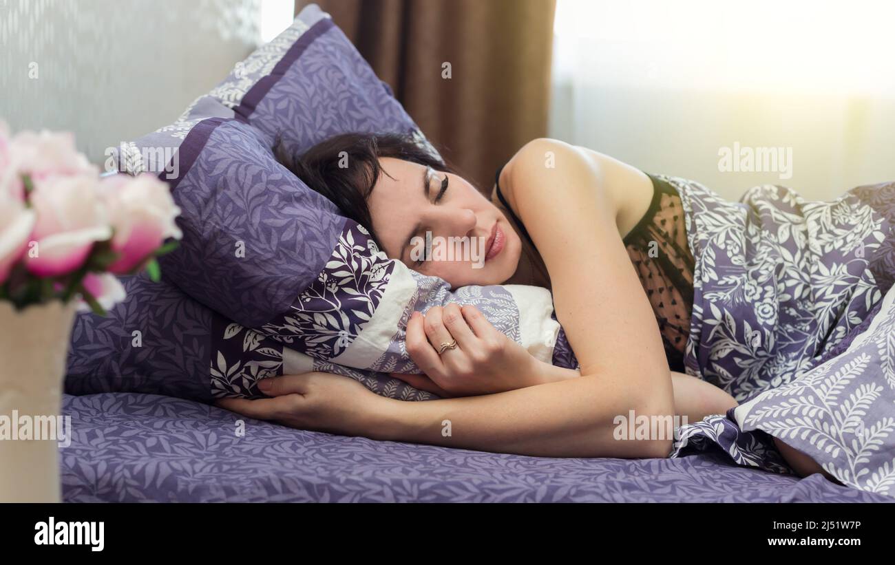 Frau schläft ruhig Schlaf in ihrem Bett am Morgen. Stockfoto