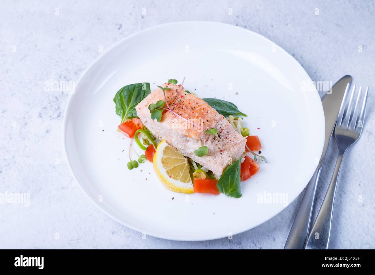 Forelle (Lachs) mit Gemüse, Zitrone und Microgreens, zubereitet nach der Confit-Methode. Traditionelles französisches Gericht. Schritt für Schritt. Nahaufnahme. Stockfoto