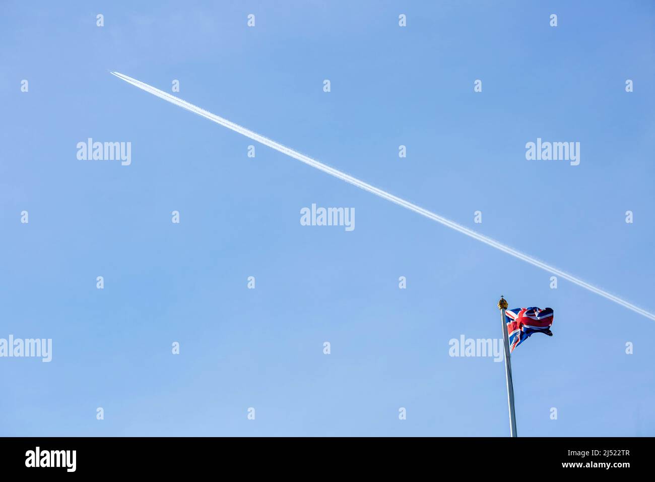 Vor dem Beitrittstag wird über einer Unionsflagge auf dem Dach des Buckingham Palace im Zentrum Londons ein Kondensstreifen gesehen. Stockfoto