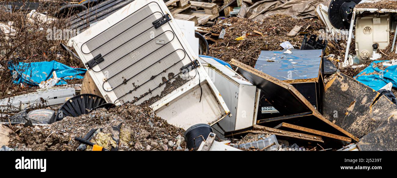 Weggeworfene Haushaltsgeräte und andere Abfälle auf einer temporären Deponie in Kyläsaari, Helsinki, Finnland. Stockfoto