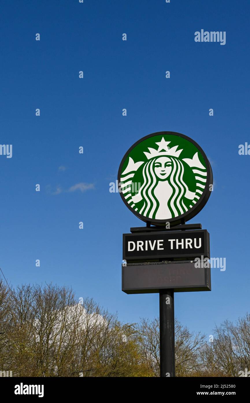Swindon, England - 2022. April: Großes Schild an der Membury-Tankstelle auf der Autobahn M4, das eine Durchfahrt-Filiale von Starbucks-Kaffee anwirbt. Stockfoto