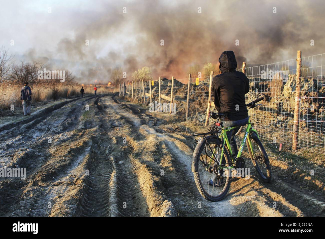 Der Radfahrer beobachtet ein großes Feuer auf dem europäischen Anwesen in Krakau, Polen. Stockfoto
